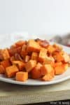 Plate of roasted diced sweet potatoes with bacon.