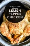 Image of a cooked lemon pepper chicken sitting on a platter next to a Ninja Foodi. Image text is "Ninja Foodi Lemon Pepper Chicken"