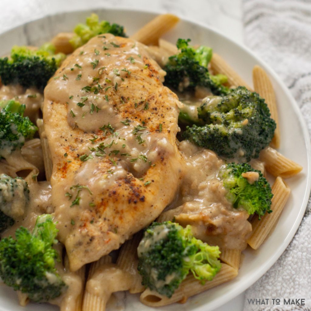 Plate of chicken breast and broccoli with a garlic cream sauce.