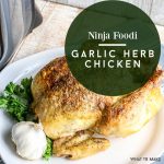 Plate with a finished garlic herb roasted chicken cooked in the Ninja Foodi. Text reads "Ninja Foodi Garlic Herb Chicken"