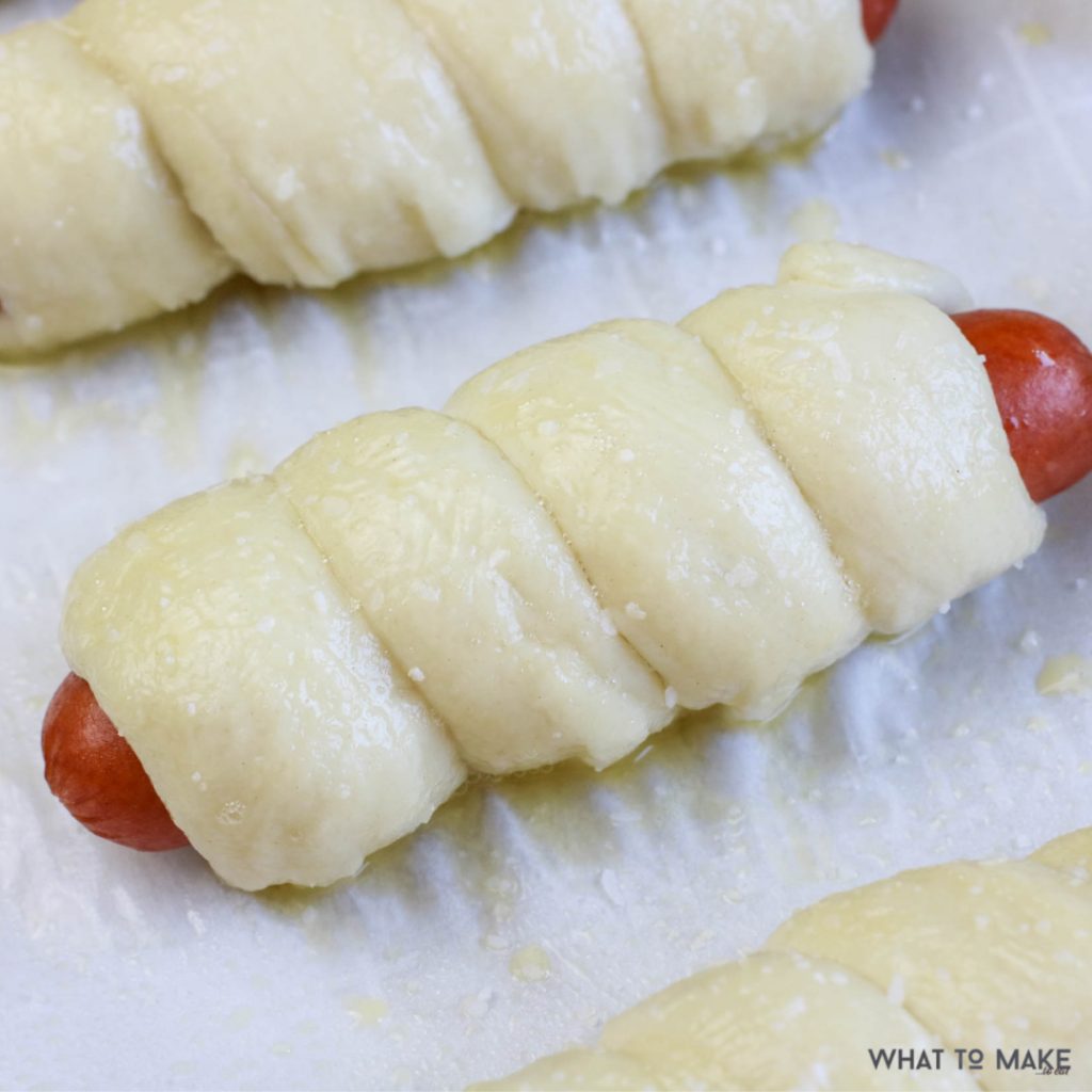 In process image of pretzel wrapped hot dogs